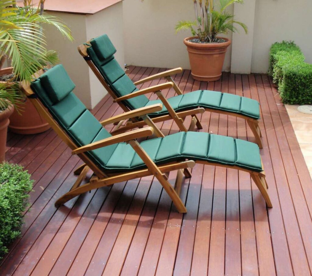 Outdoor seating with green cushion covers on a deck