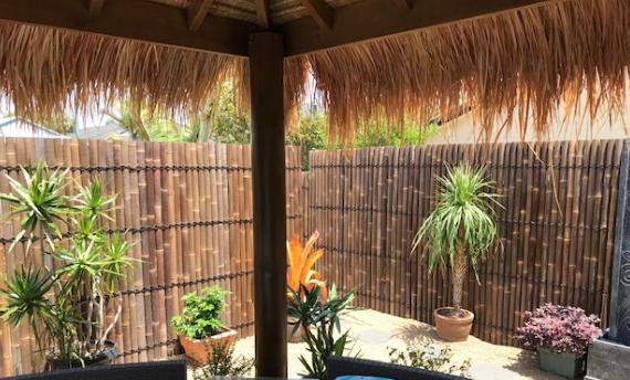Quality bamboo panels surrounding an african thatch roof gazebo